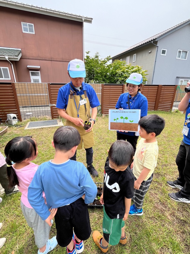 間引きの説明を聞く園児