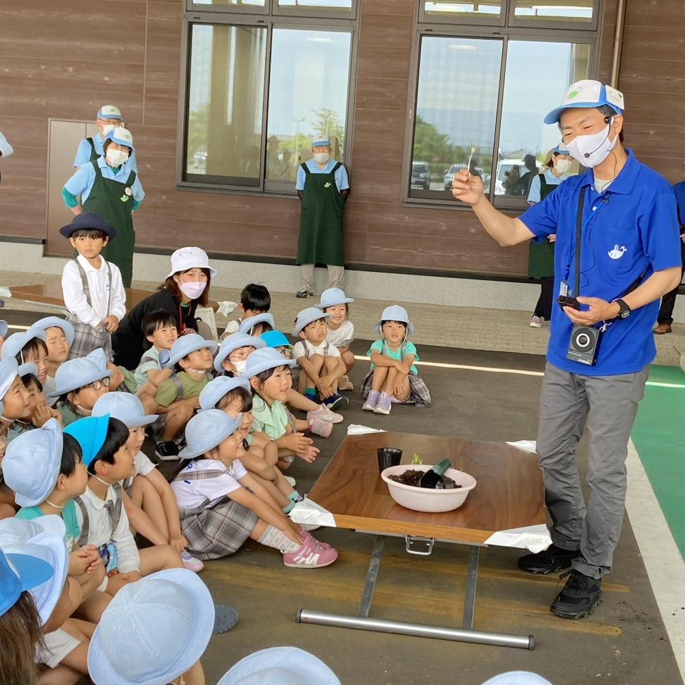 右手にフォークを持った寺井先生が園児達の前で説明をしている写真