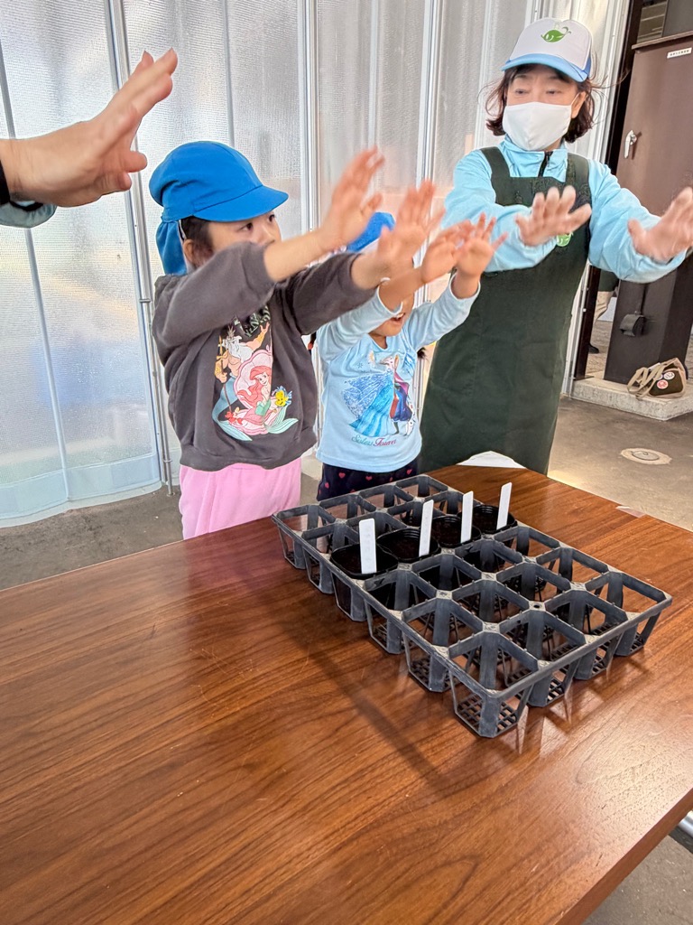 種におまじないをかける園児