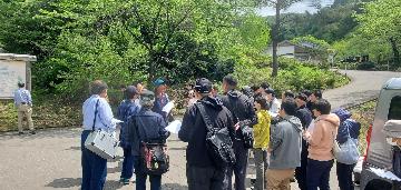 NPO法人カラミの街保存会の案内に耳を傾けるカラミめぐり参加者
