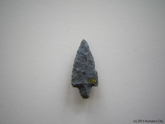 灰色で矢じりの形をした打製石鏃 通番号:647の写真