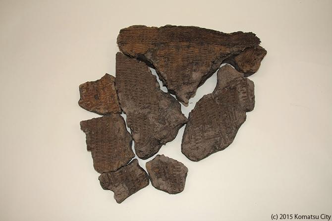 7つほどの大小様々な茶色の物体が繋がるように配置して置かれており、それぞれの表面には交差したような跡がついている写真