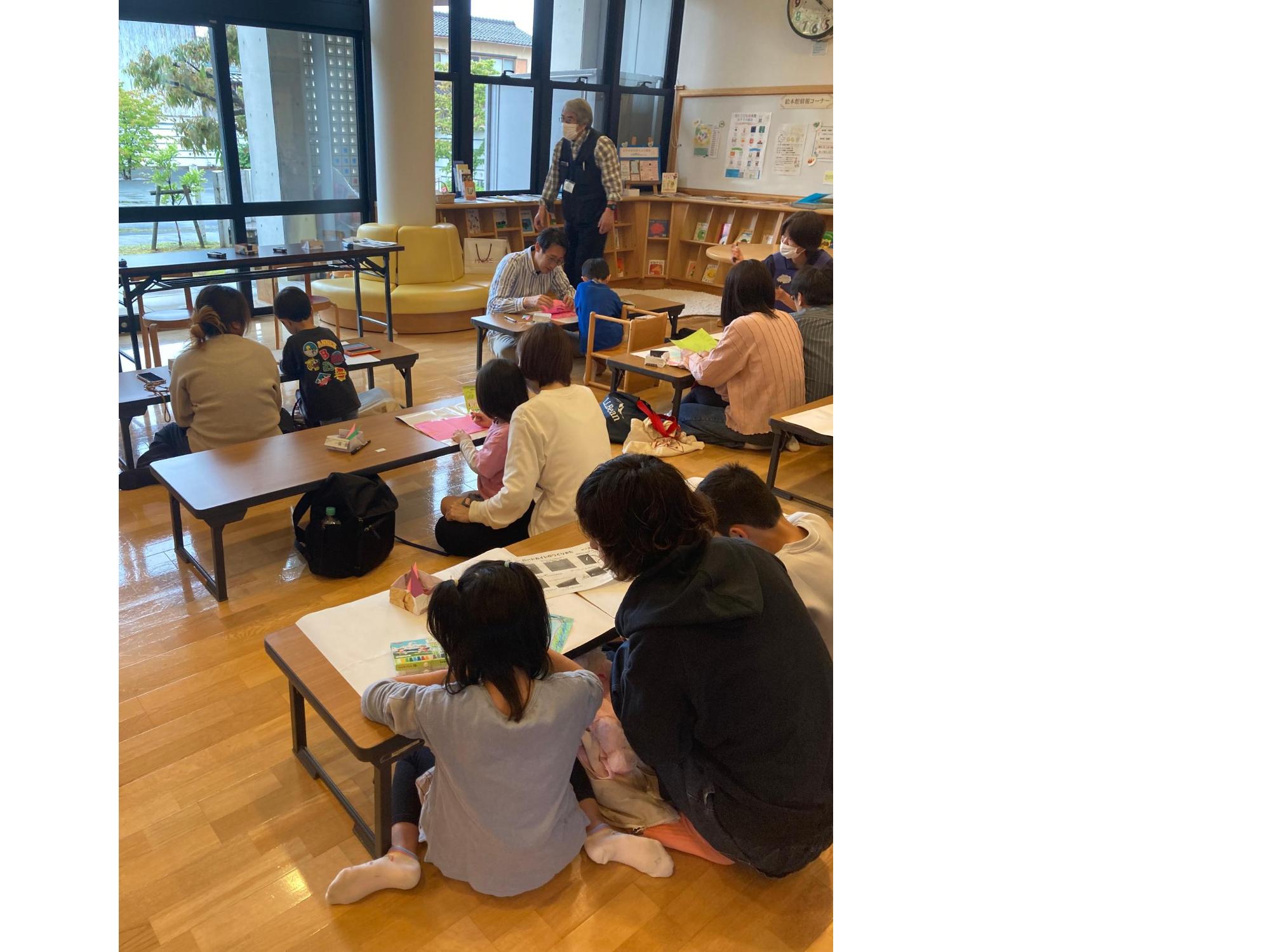 親子で色画用紙に鳥の羽の模様を描いている画像