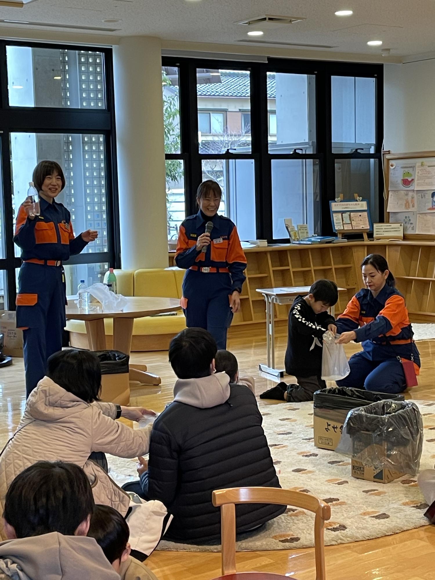 小松市消防団女性分団の方々が簡易トイレの説明をしている画像