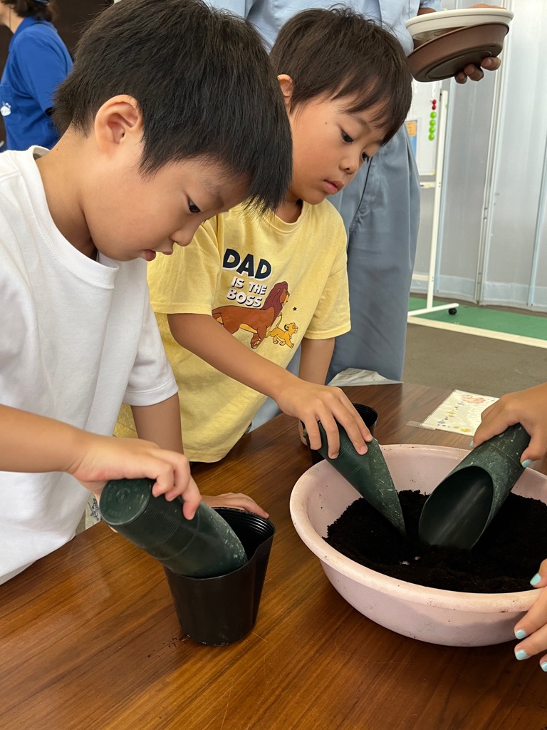ポットに土を入れる園児