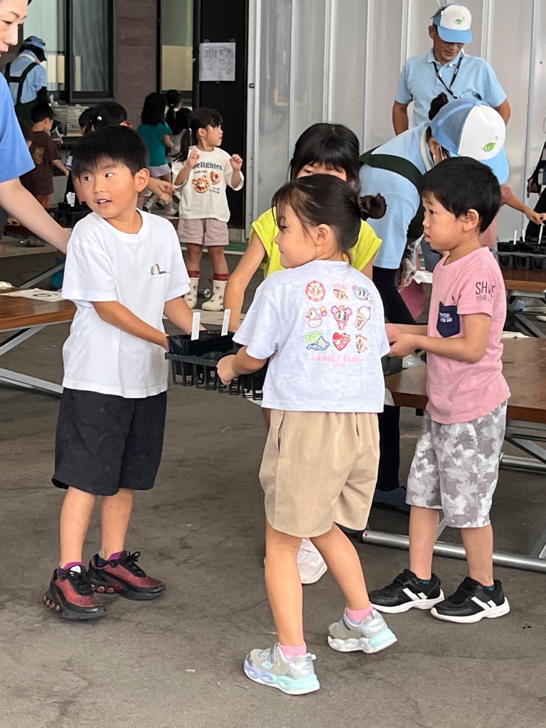 ポットを水場まで運ぶ園児
