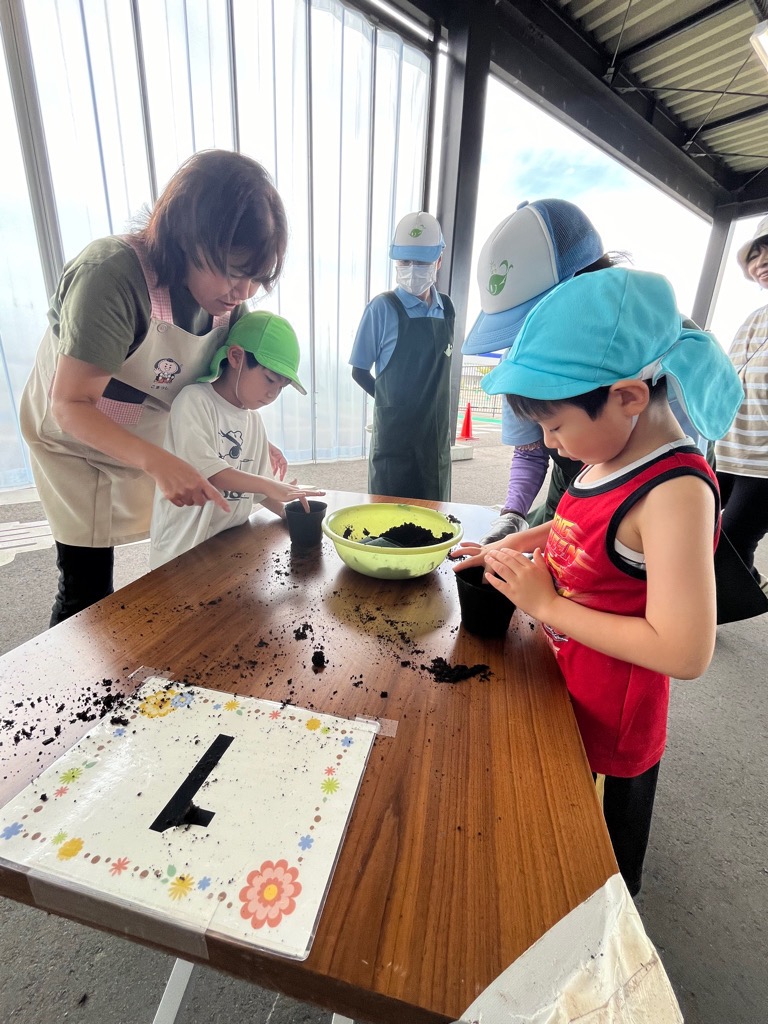 土に指で穴を空ける園児