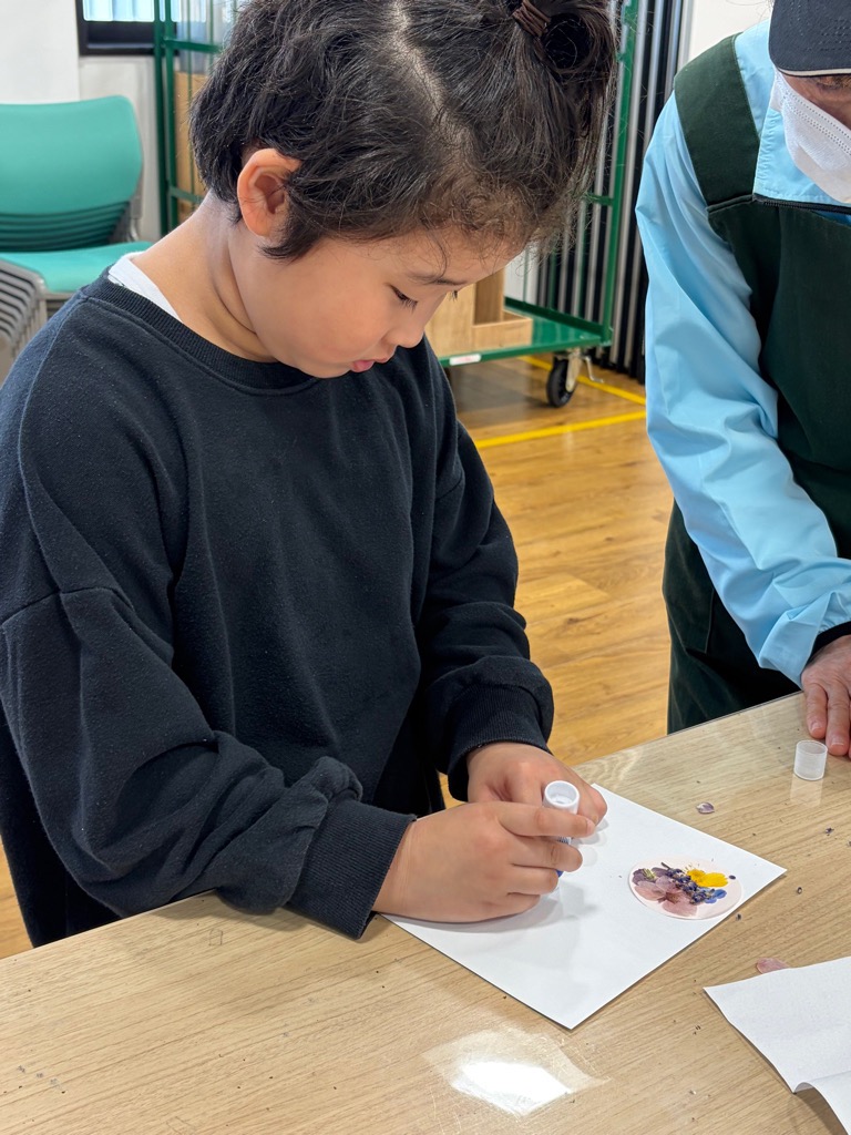 台紙に押し花を貼る園児