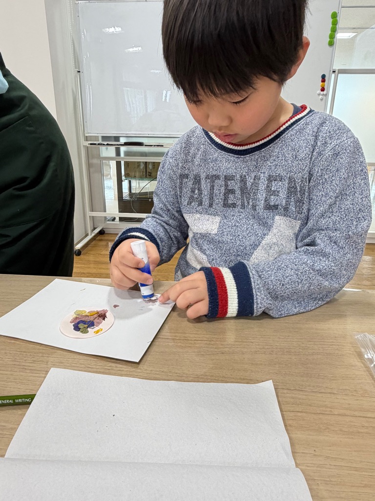 押し花を台紙に貼る園児