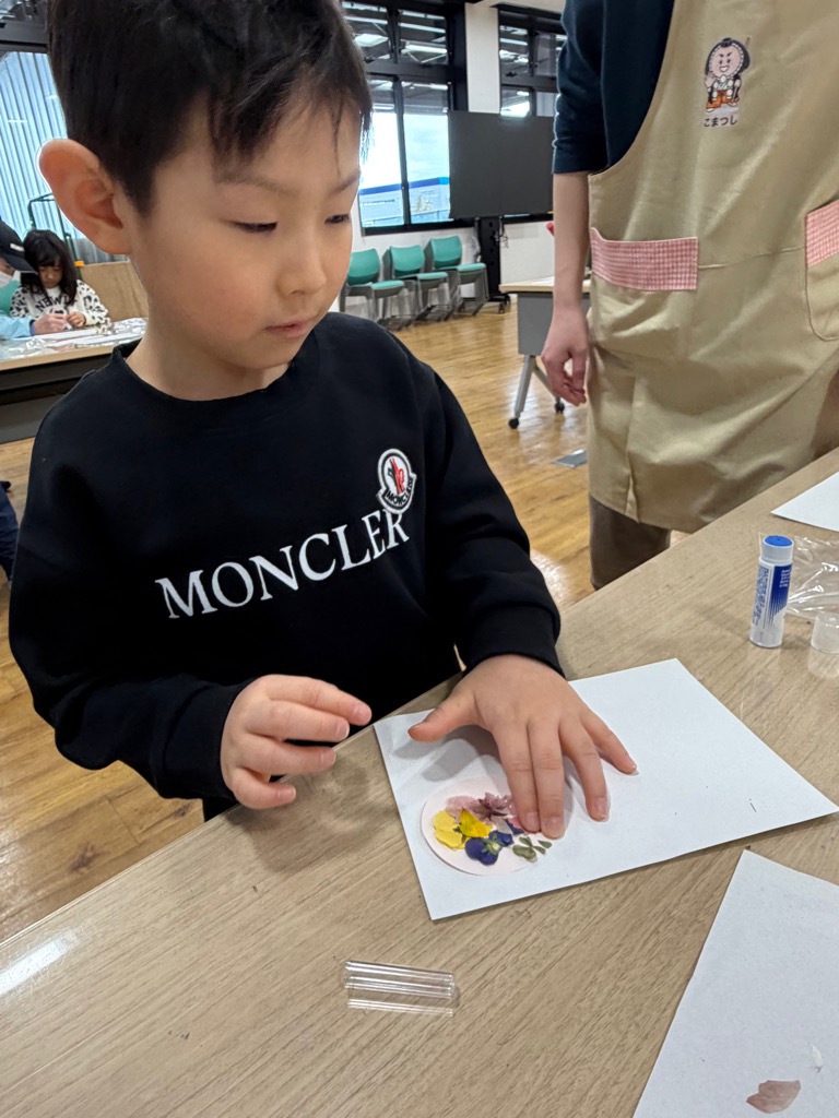 押し花を台紙に貼る園児