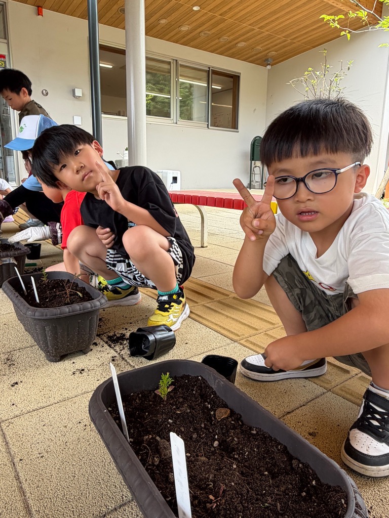 苗を植え終わって喜ぶ園児