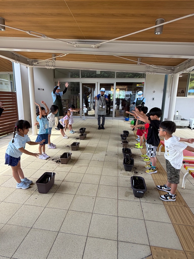 植えた苗におまじないをかける園児