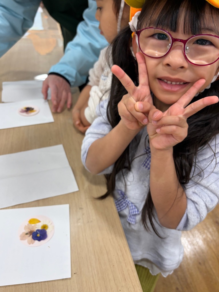 台紙に押し花を乗せる園児