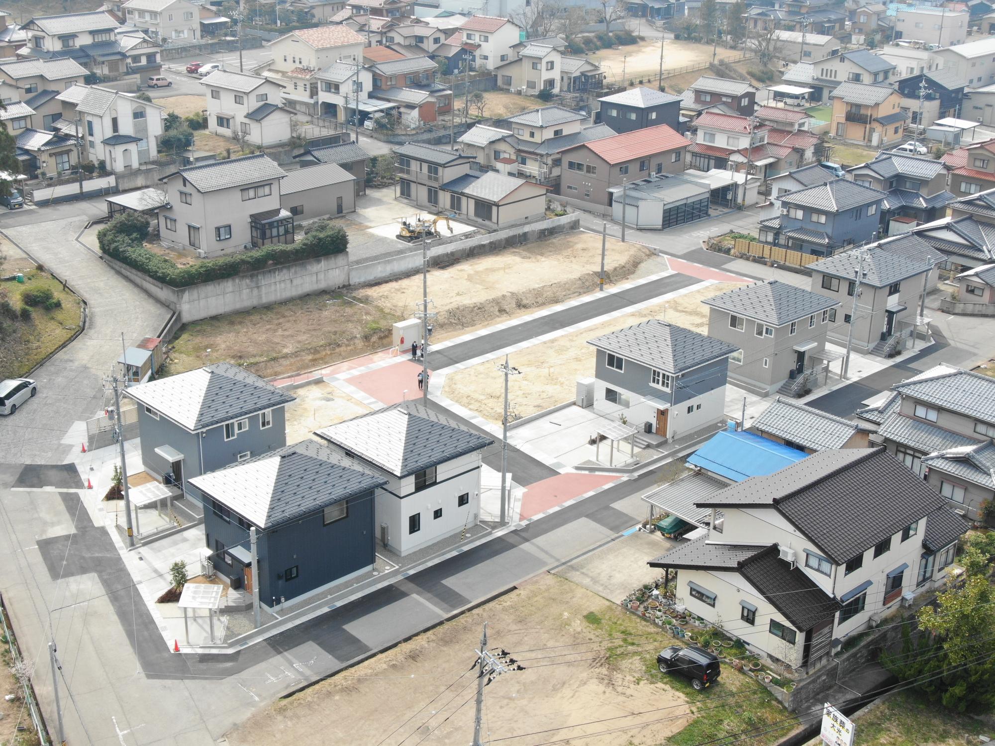 複合遊具が設置されている右側の敷地内の道路側に駐車場、奥にグレーの外壁で3階建ての地域優良賃貸住宅の外観写真