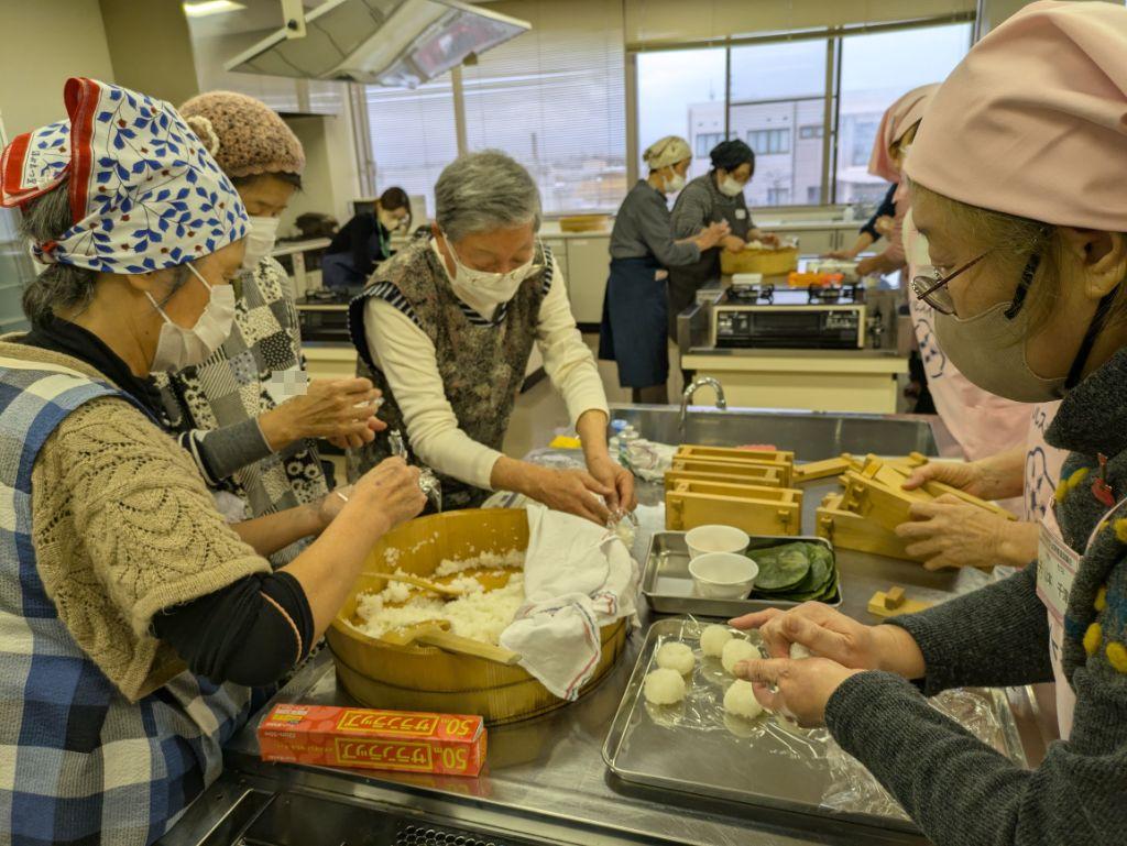 参加者と食改さんが酢飯をにぎる様子