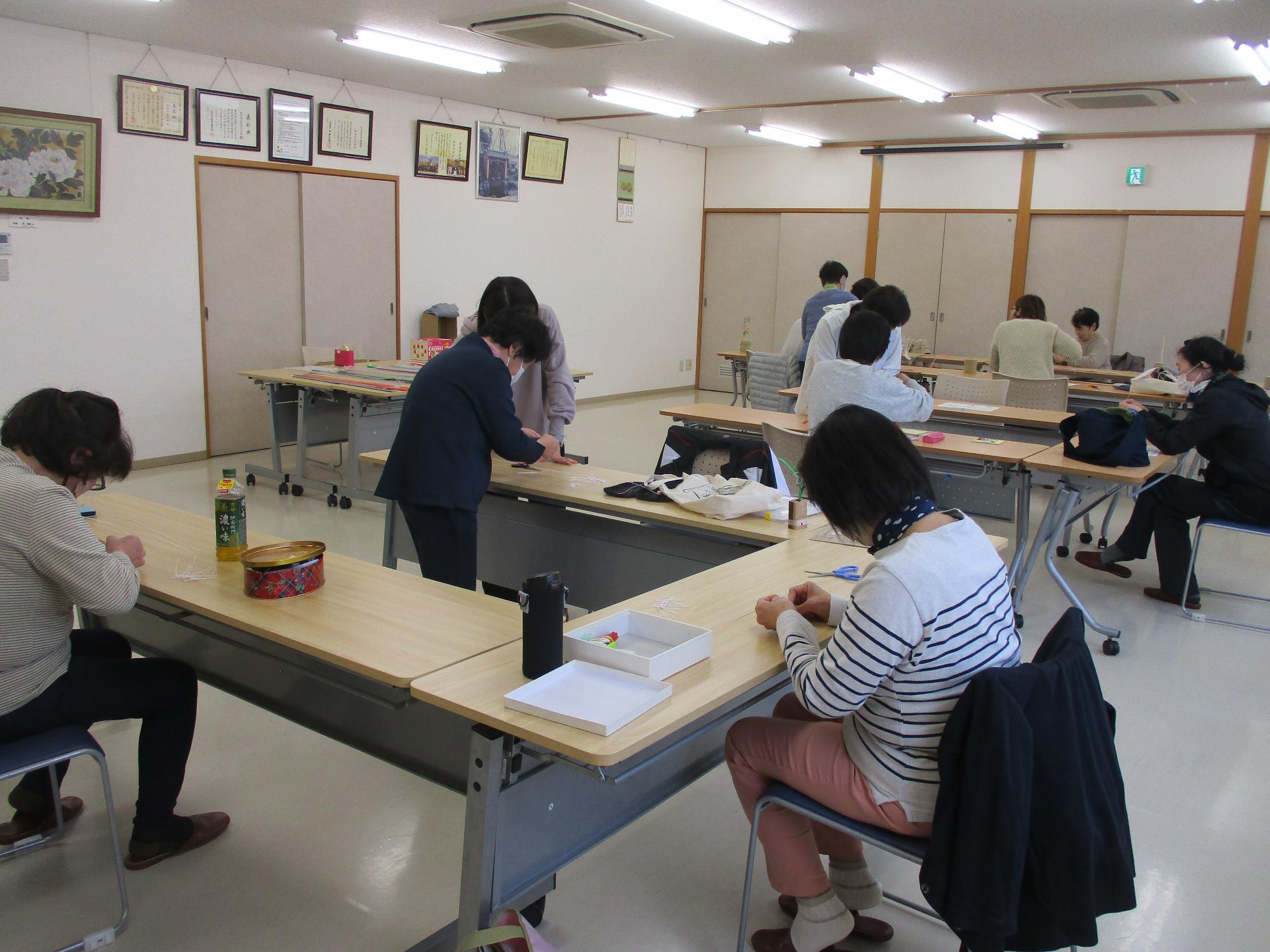 講師の指導を受けながら水引を作成している写真