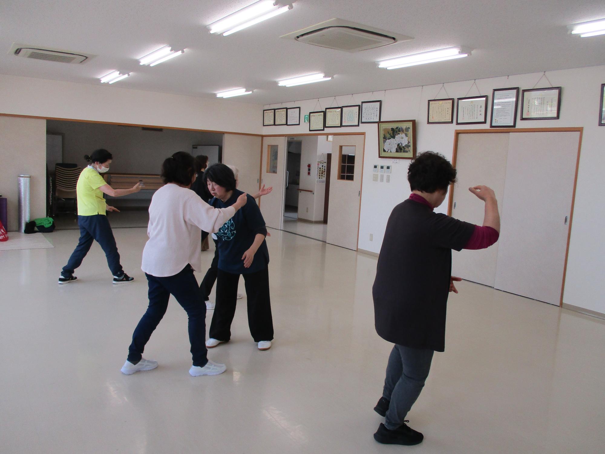 体の前で両手を上下にして講師の指導を受けている写真