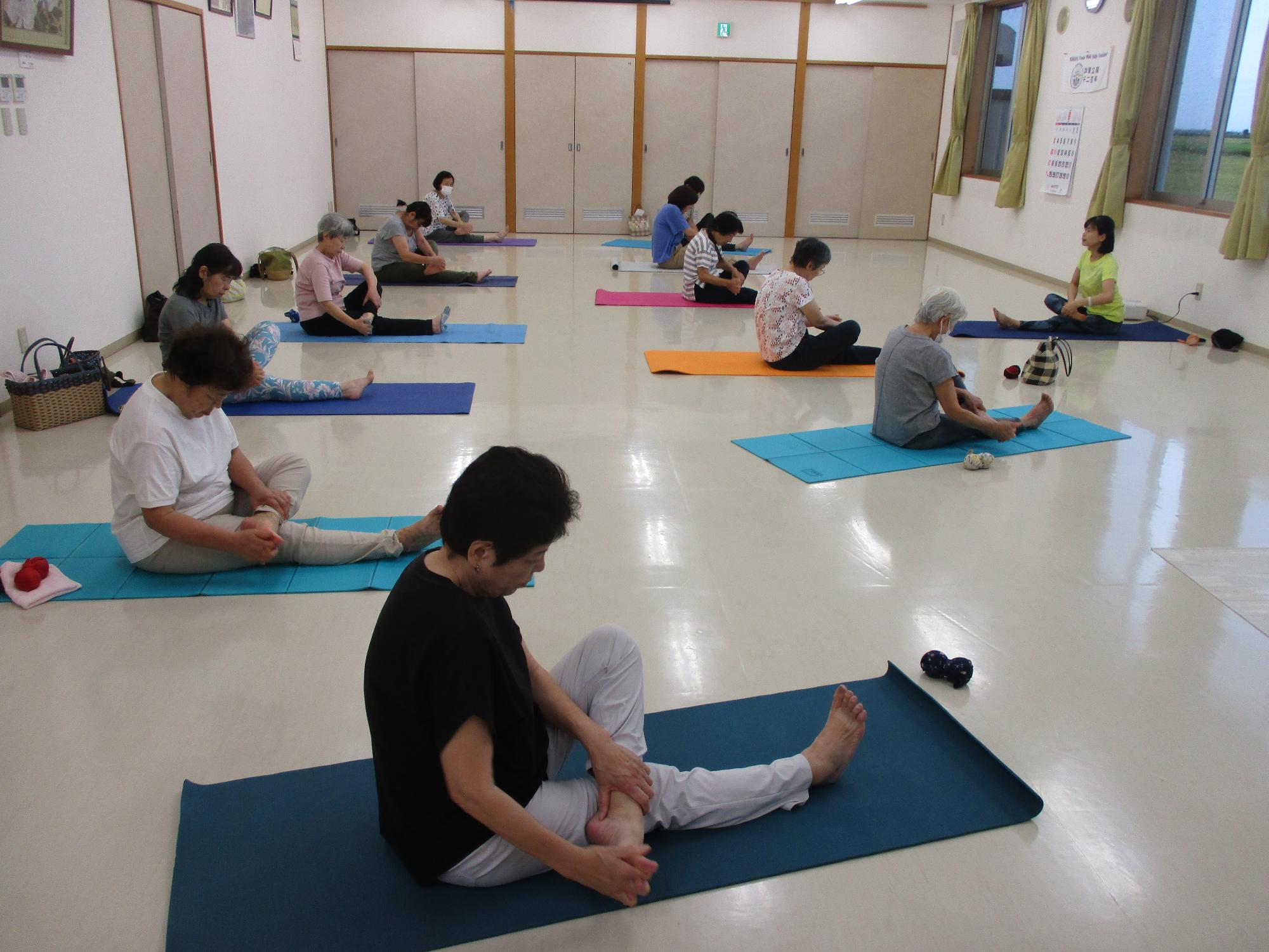 長座位に左足を乗せ手で足首を回している写真