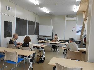 教室の中で男性1名と女性2名の参加者が講師の説明を聞く様子