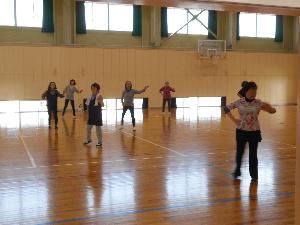体育館の中で受講生と講師がリズムダンスを行う様子