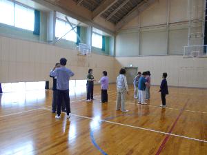 体育館の中で8名の男女が太極拳の練習をする様子