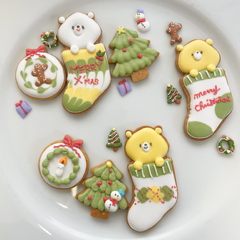 クリスマスのアイシングクッキーの画像。かわいいクマとツリーの形のクッキーに白や黄色赤色のアイシングが施されています。