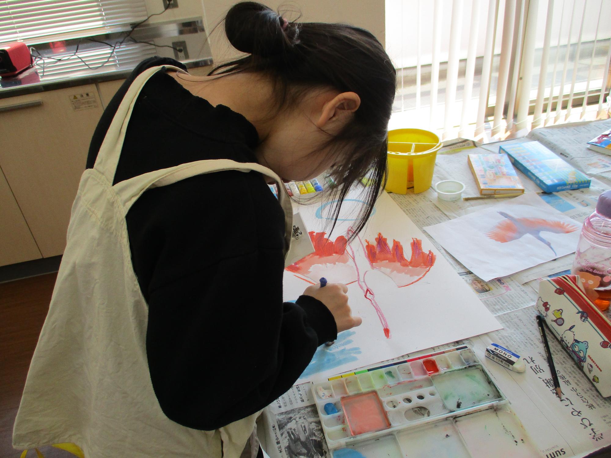 鳥の絵を一生懸命書いている女の子