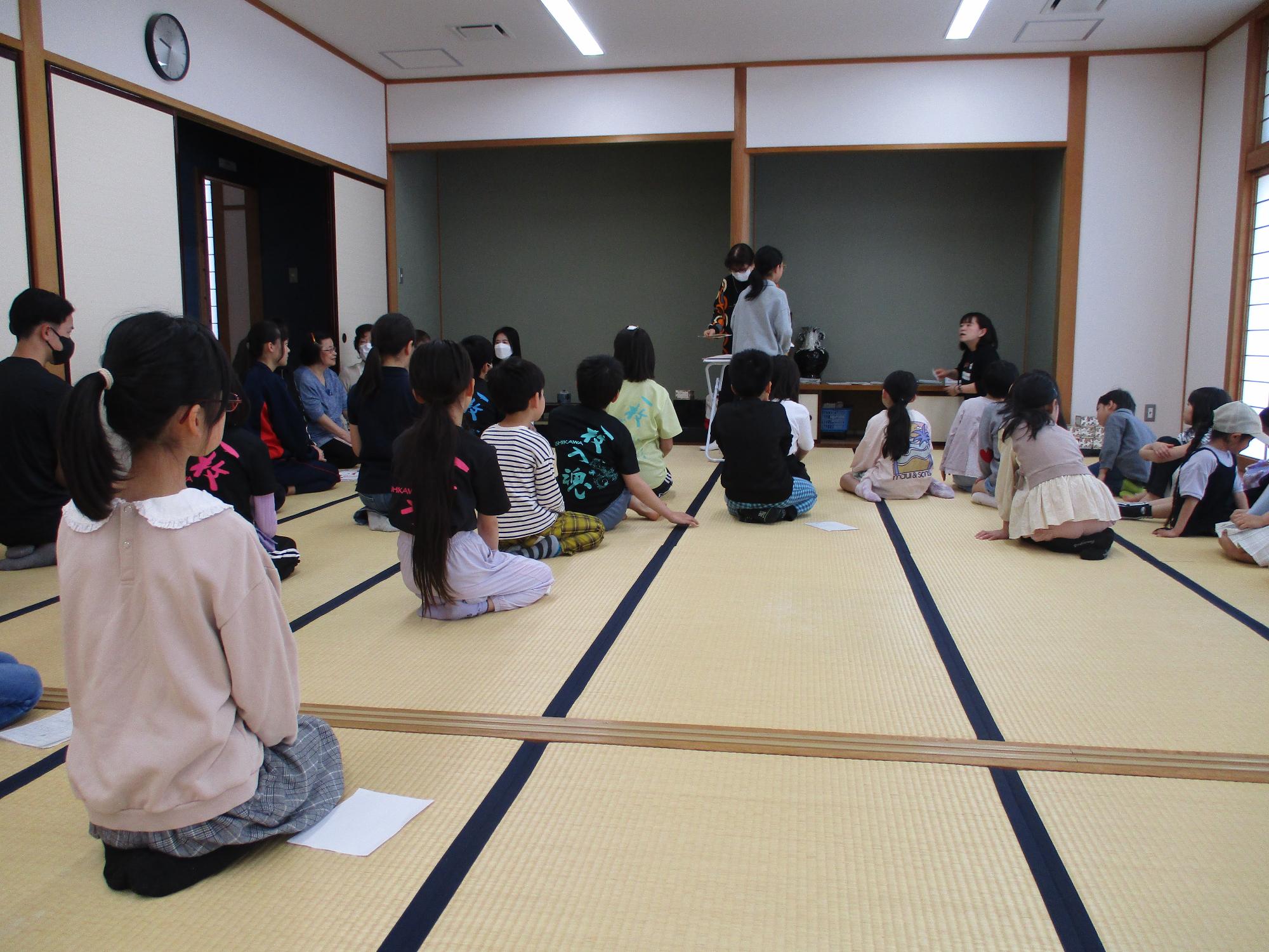 ジュニア百人一首教室が始まる前のあいさつ。みんなが正座で先生の話を聞いている。