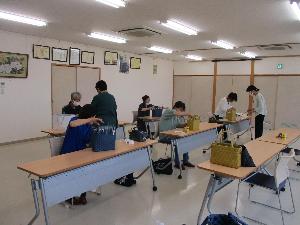 紙バンドでエコバックの作品を作る受講生の写真