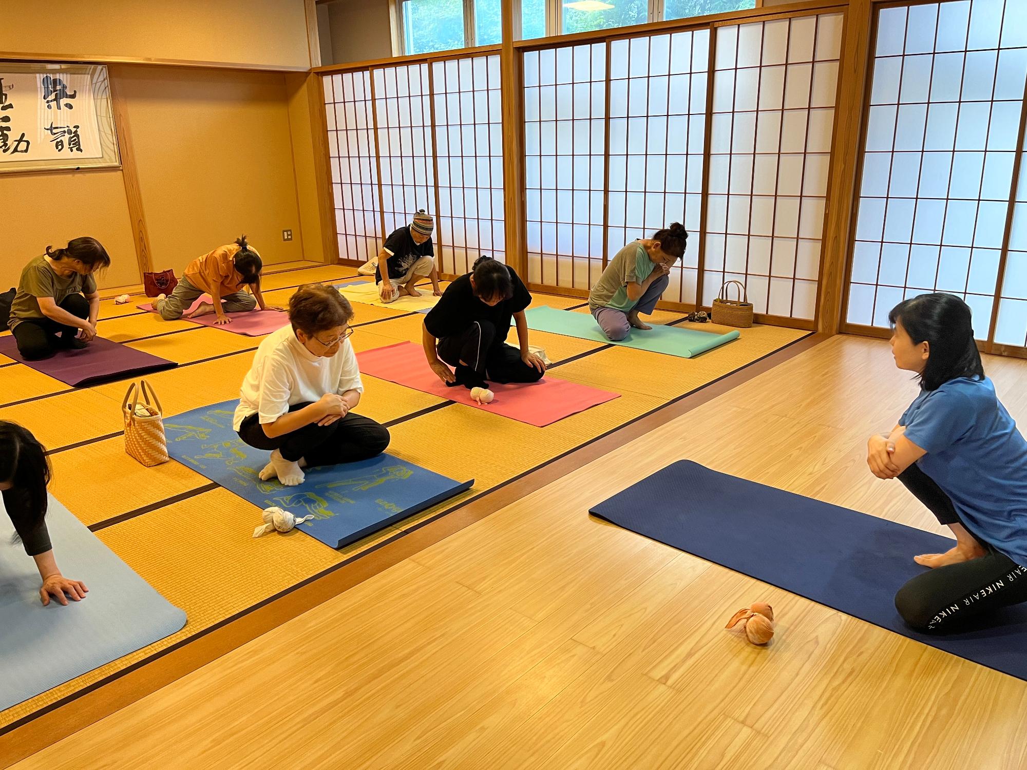 和室でマットをつかいヨガのストレッチをしている様子