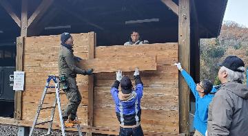 力を合わせて板を持ち上げる様子