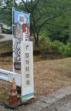 駐車場の案内板とからみめぐりの幟り旗