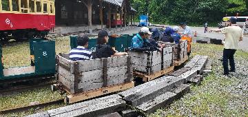鉱山電車（木製の鉱車）に乗車する参加者