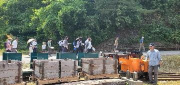 鉱山電車の向こう側を歩くカラミめぐりの参加者