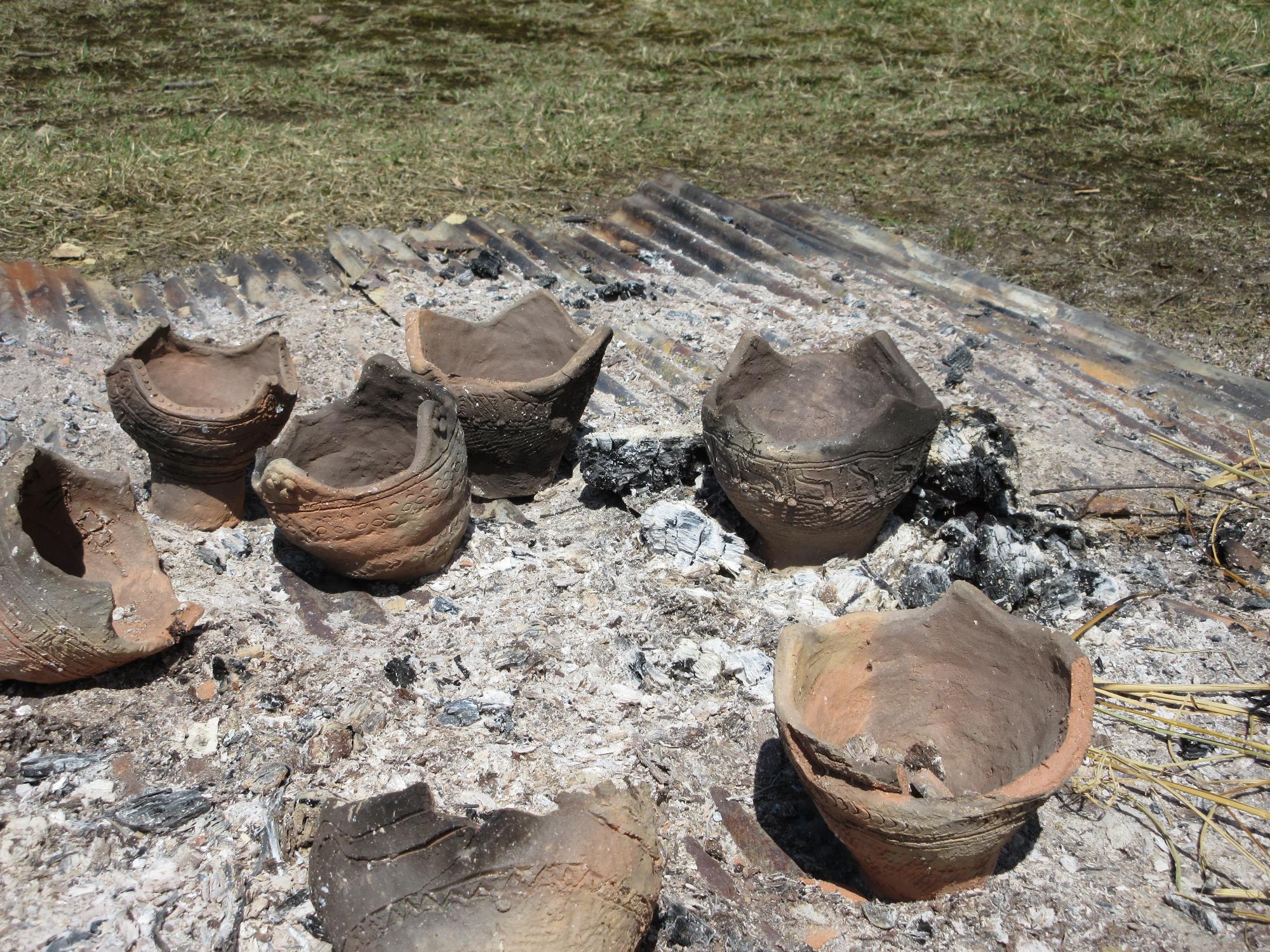 トタンの上にあった薪は灰となり、焼きあがった土器が並んでいる写真
