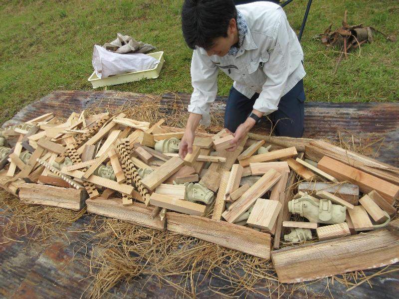 馬形埴輪を並べた上にマキをかぶせる様子