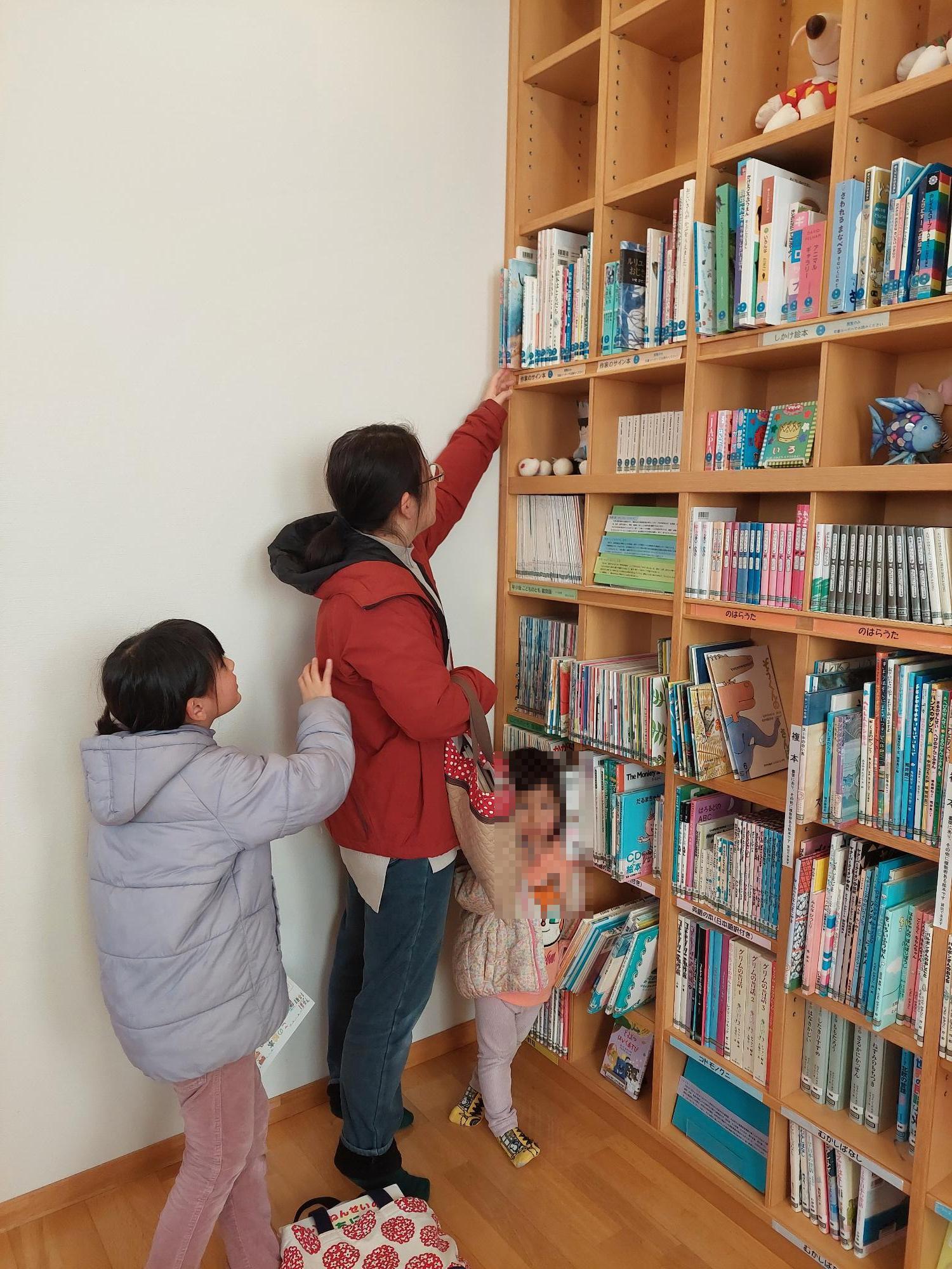 絵本を探す親子の画像